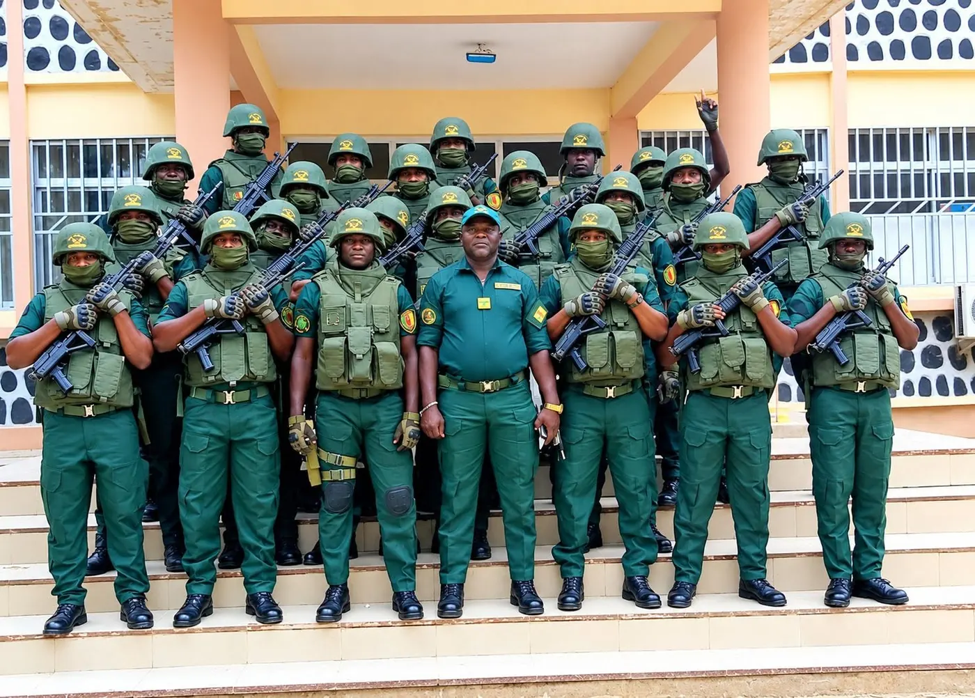 Unité en tenue verte, casquée et armée, posant sur les marches d'un bâtiment