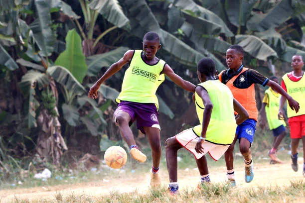 Jeunes footballeurs en chasubles disputant un ballon